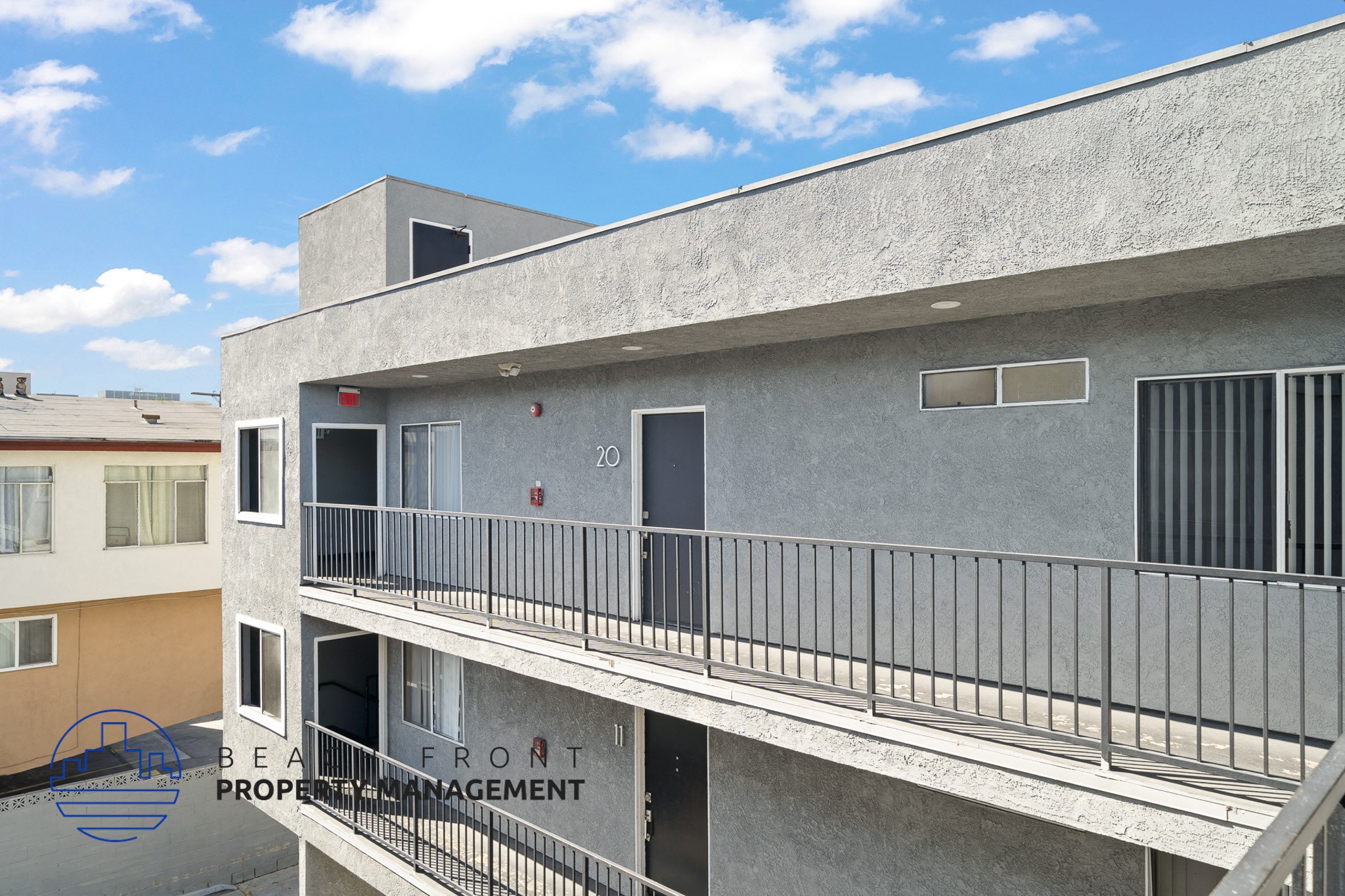 A building with a balcony and a sign that says "BEACH FRONT PROPERTY MANAGEMENT".
